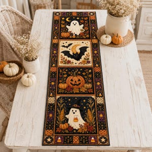 May include: A rectangular table runner featuring a black background with four distinct panels depicting Halloween themes including a white ghost, a black bat with a crescent moon, a jack-o'-lantern, and a ghost wearing a witch hat among corn.
