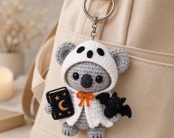 Llavero de koala de Halloween tejido a crochet, koala disfrazado de fantasma con libro de hechizos y murciélago, colgante para bolso amigurumi, regalo de animal espeluznante
