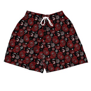 Könnte beinhalten: Schwarze Shorts mit rotem und weißem Paisley-Muster. Die Shorts haben einen weißen Kordelzug und sind aus leichtem Material gefertigt. Geeignet für warme Tage.