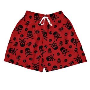 Könnte beinhalten: Hellrote Shorts mit einem durchgehenden schwarzen Totenkopf- und Knochenmuster. Die Shorts haben einen elastischen Bund mit einer weißen Kordel, die in der Mitte gebunden ist. Der Stoff zeigt einen sich wiederholenden Druck verschiedener Totenköpfe.