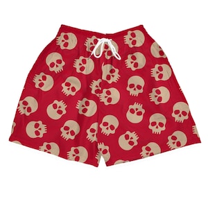 Könnte beinhalten: Rote Shorts mit einem sich wiederholenden Muster aus beigefarbenen Totenköpfen. Die Shorts haben einen weißen Kordelzug. Die Totenköpfe sind gleichmäßig über den Stoff verteilt.