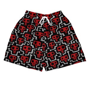 Könnte beinhalten: Schwarze Badeshorts mit einem sich wiederholenden Muster aus roten Totenköpfen und weißen Knochen. Die Shorts haben einen weißen Kordelzug. Sie bestehen aus leichtem Material und eignen sich zum Schwimmen und für Wasseraktivitäten.