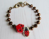 Handmade artisan ceramic and glass bead bracelet in red and bronze with house and ladybird beads - songbead, eclectic colourful jewellery