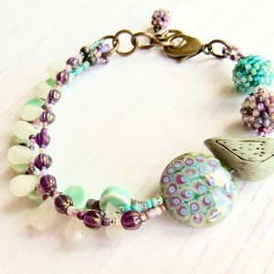 Crocus handmade artisan bead bracelet in deep purple and fresh turquoise with bird detail Songbead, UK, narrative jewelry image 5