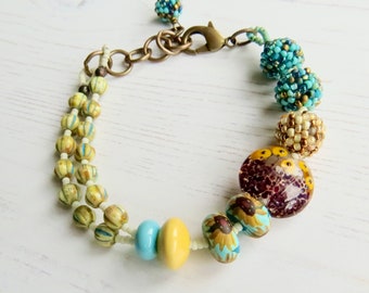 Handmade artisan bead bracelet in sunny yellow and turquoise-blue - Sunflower Fields - Songbead, UK, narrative jewelry