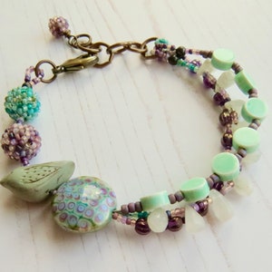 Crocus handmade artisan bead bracelet in deep purple and fresh turquoise with bird detail Songbead, UK, narrative jewelry image 8