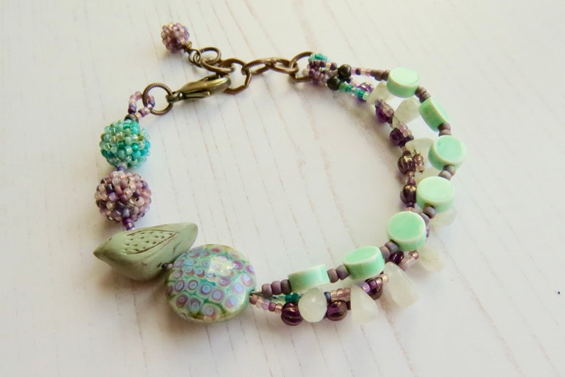 Crocus handmade artisan bead bracelet in deep purple and fresh turquoise with bird detail Songbead, UK, narrative jewelry image 8