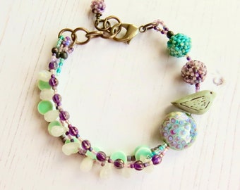 Crocus - handmade artisan bead bracelet in deep purple and fresh turquoise with bird detail - Songbead, UK, narrative jewelry