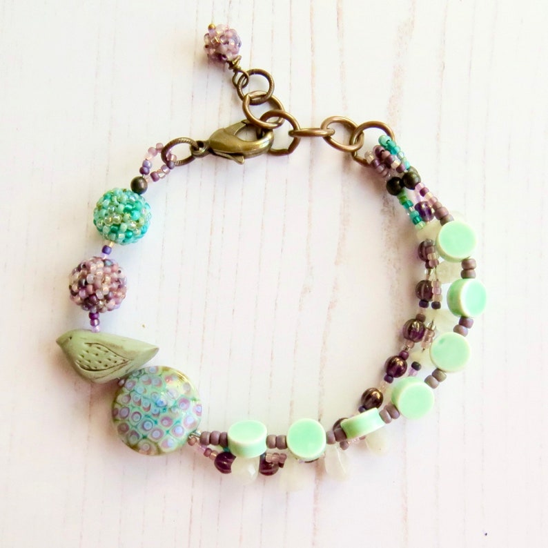 Crocus handmade artisan bead bracelet in deep purple and fresh turquoise with bird detail Songbead, UK, narrative jewelry image 4