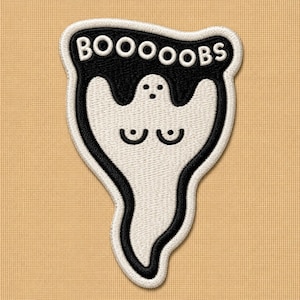 May include: Embroidered patch featuring a white ghost with black outlines and the word "BOOOOOBS" in black. The ghost has two small circles for eyes and two curved lines for a mouth. The patch is on a tan background.