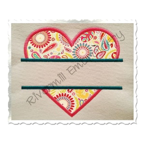 May include: Embroidered heart design with a floral paisley pattern in red, yellow, and blue. The heart has a red border and two teal horizontal lines for text. The text "Rivermill Embroidery" is visible on the side.