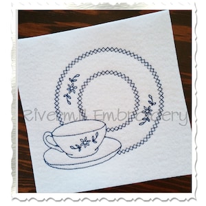 Puede incluir: Un diseño de bordado en blanco y negro de una taza de té y un platillo con un patrón floral. El diseño está sobre un fondo de tela blanca.