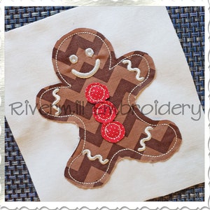May include: A brown gingerbread man applique with white stitching and red buttons. The gingerbread man is on a white background.