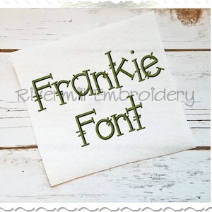 May include: A white piece of paper with the text "Frankie Font" written in a green, stitched font.