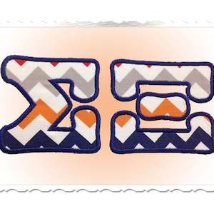 May include: Two fabric letters, "Z" and "E", in a blue, white, orange, and grey chevron pattern. The letters are outlined in dark blue.