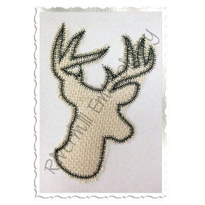 May include: A burlap deer head applique with a green outline. The deer head is a simple silhouette with large antlers.