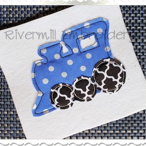 May include: Blue and white polka dot train applique with black and white patterned wheels. The train is outlined in black thread.