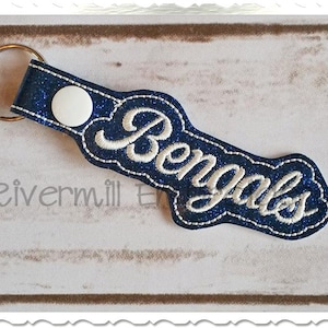 May include: Blue glitter keychain with a white embroidered "Bengals" logo.