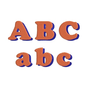 May include: Orange embroidered letters ABC and abc with a blue shadow effect. The letters are in a bold, rounded font, and the embroidery gives them a textured appearance. The letters are arranged on a white background.