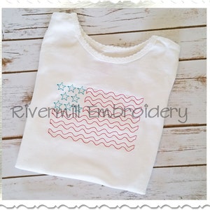 May include: White tank top with an embroidered American flag design. The flag is red, white, and blue with wavy lines for the stripes and blue stars in the canton.