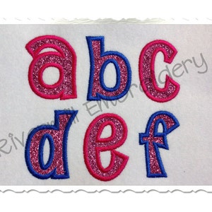 May include: Embroidered letters a, b, c, d, e, and f in a bubble font. The letters are pink with a blue outline and have a glittery texture.