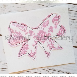 Op de afbeelding: Een roze en witte stoffen strik met een damastpatroon. De strik is omrand met zwarte draad.