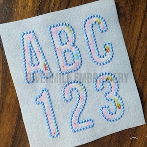 May include: A set of felt letters and numbers with a floral pattern. The letters are A, B, and C. The numbers are 1, 2, and 3.