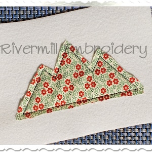 May include: A white felt background with a red and green floral fabric mountain applique. The applique is stitched with a black thread. The text "Rivermill Embroidery" is visible in the top left corner of the image.