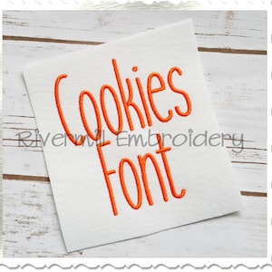May include: White square with the words "Cookies Font" in orange script. The text "Rivermill Embroidery" is below the text. The background is a light wood grain.