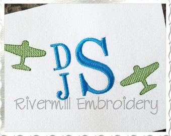 Op de afbeelding: Geborduurde monogram met de letters "DJ" en "S" in blauw, met twee groene vliegtuigontwerpen. De tekst "Rivermill Embroidery" staat onder het monogram.