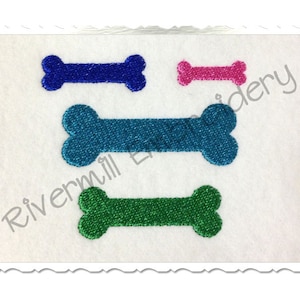 May include: Three embroidered dog bone shapes in blue, teal, and green on a white background.