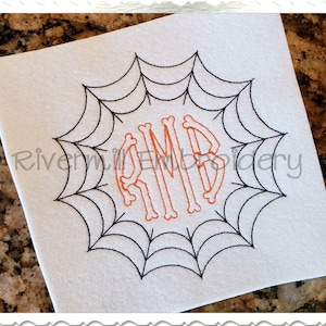 May include: White square fabric with a black spiderweb design around the edge. Inside the web is the embroidered letters "RMB" in orange, bone-like font. The text "Rivermill Embroidery" is in the lower left and right corners.