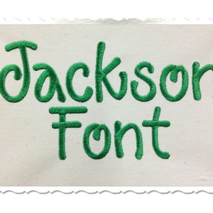 Op de afbeelding: Groene geborduurde tekst op een witte achtergrond met de tekst "Jackson Font".