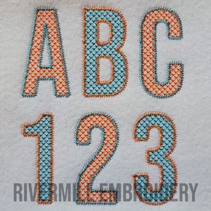 以下が含まれることがあります： ターコイズとオレンジのカラーリングで刺繍されたアルファベットのA、B、C、数字の1、2、3。文字はオレンジで縁取りされ、ターコイズで塗りつぶされ、数字はターコイズで縁取りされ、オレンジで塗りつぶされています。文字と数字は白い布地に刺繍されています。画像の下部には「Rivermill Embroidery」というテキストが表示されています。