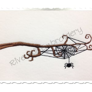 May include: A black spider hangs from a brown branch with a black spider web. The web has a decorative design with swirls.