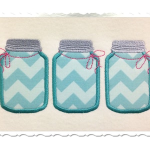 Könnte beinhalten: Drei türkisblaue Einmachgläser mit weißen Zickzackmustern und roten Schnüren.