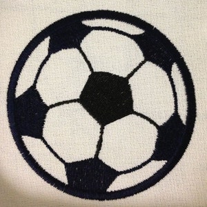 May include: A black and white embroidered soccer ball with a stitched design. The ball is round and has a classic soccer ball design.