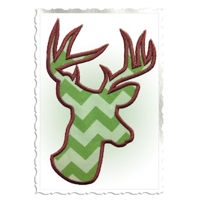 May include: Green and brown embroidered deer head silhouette with a chevron pattern.