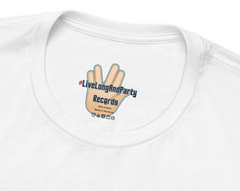 May include: A white t-shirt featuring a printed inner neck label. The label displays a tan hand making a Vulcan salute gesture, the text #LiveLongAndParty Records, 100% Cotton, Made in Honduras, and a row of small black laundry care icons.