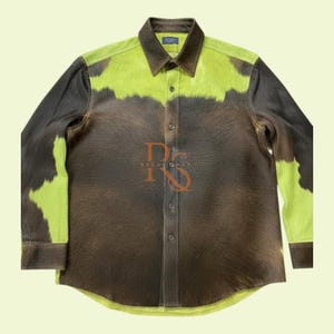 以下が含まれることがあります： ユニークなデザインのボタンダウンシャツ。シャツは、肩と胸上部にライムグリーンのアクセントが付いた茶色と黒のパターンが特徴です。襟と袖口は濃い茶色です。シャツはクラシックな襟とボタン留めです。