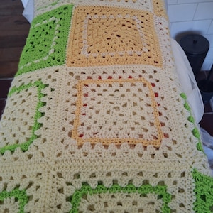 May include: A white ceramic mug with a black handle and the text "But First, Coffee" in a black, bold font. The mug is on a wooden surface. The mug is approximately 10 cm tall.