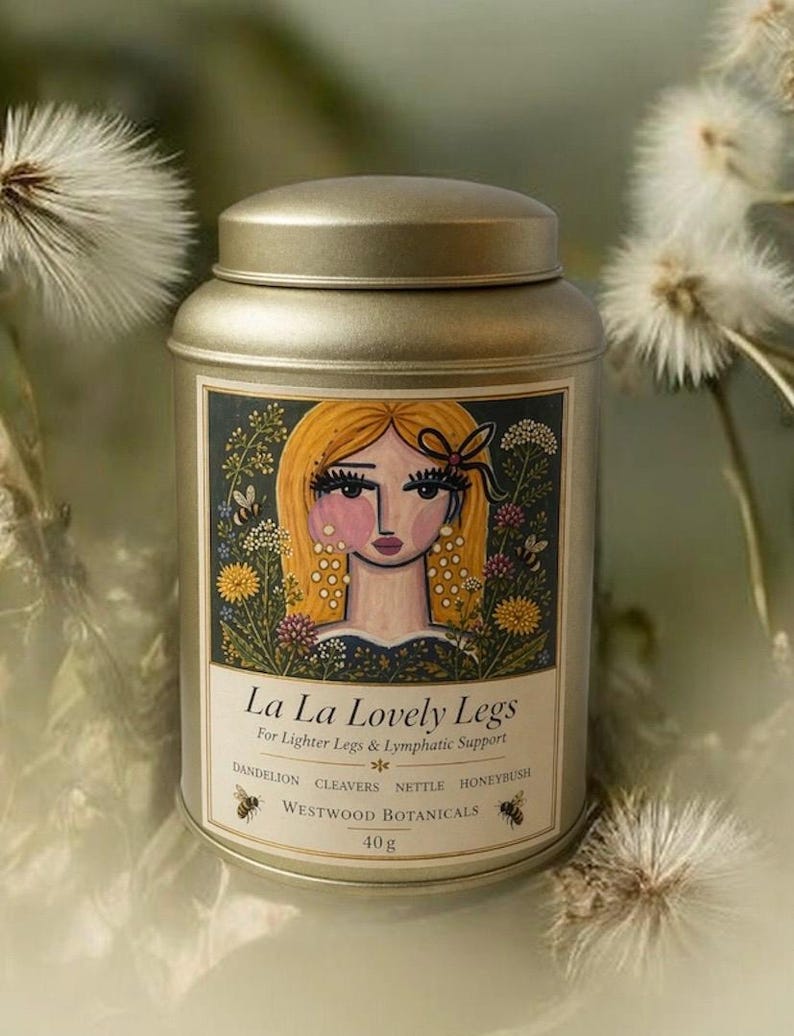 May include: A gold-colored metal tin with a lid, featuring a label with the text "La La Lovely Legs" and an illustration of a woman with blonde hair. The label also lists ingredients and the weight of the product, 40g.