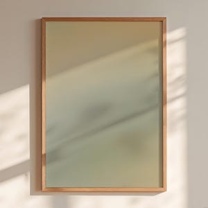 May include: A rectangular wall art piece featuring a smooth, vertical color gradient that transitions from a warm, light beige at the top to a muted, soft sage green at the bottom, all encased within a simple, light-toned wooden frame.