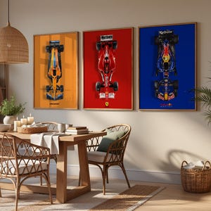 May include: Three framed Formula 1 car prints. The prints feature top-down views of race cars against orange, red, and blue backgrounds. The room has a wooden dining table, wicker chairs, and a woven pendant light.
