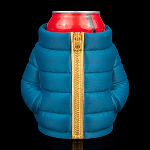 May include: A teal-colored can cooler shaped like a puffer jacket with a gold zipper. The cooler is holding a red can with a black stripe. The background is black.