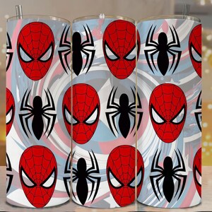 Op de afbeelding: Drie roestvrijstalen bekers met een herhaald patroon van Spider-Mans masker en spinnenembleem. Het ontwerp bevat rode, witte en blauwe wervelingen. Elke beker heeft een zilveren rietje.