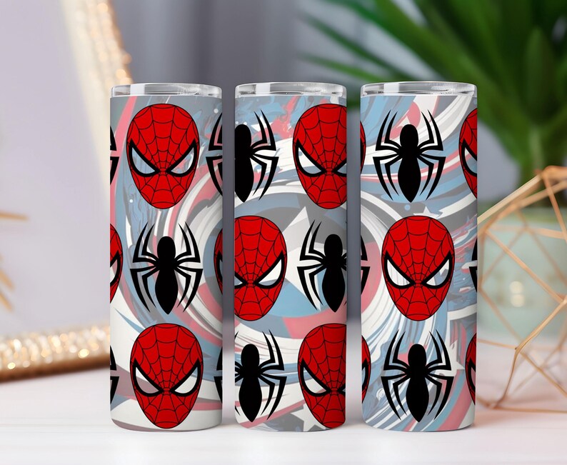Op de afbeelding: Drie roestvrijstalen bekers met een herhalend patroon van Spider-Mans masker en een zwart spinnenembleem. De achtergrond heeft een wervelend ontwerp in tinten rood, wit en blauw.