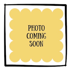May include: A square graphic with a thick black border enclosing a pale yellow scalloped shape. Centered within the yellow area is the black text "PHOTO COMING SOON" written in a simple, sans-serif font. The design is flat and minimalist.