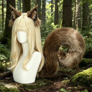 May include: A blonde wig with straight hair and bangs displayed on a white mannequin head. The wig features two pointed, brown and white faux fur animal ears attached to the top. A long, thick, brown and white faux fur tail curls behind.