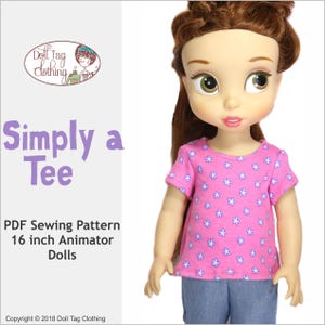 Peut inclure: Un patron de couture PDF pour un t-shirt simple pour poupées Animator de 40,6 cm. Le patron est pour un t-shirt rose avec un imprimé floral blanc. Le texte "Simply a Tee" est en lettres violettes sur fond blanc.